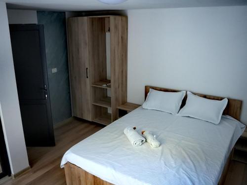 ein Schlafzimmer mit einem Bett, auf dem zwei Handtücher liegen in der Unterkunft Defileu in Bumbeşti-Jiu