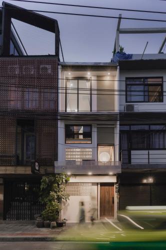 a building with a person walking in front of it at LumiLoft in Bangkok