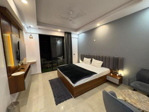 ein Schlafzimmer mit einem Bett, einem Fernseher und einer Couch in der Unterkunft Omaxe New Hazratganj in Nalmatha