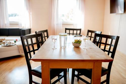a wooden table with wine glasses and a bowl of fruit on it at Hotel Donau-Ries in Mertingen