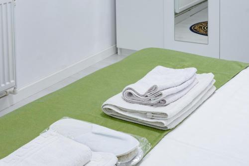 a pile of white towels sitting on a green rug at Hotel Palas Grand View in Iaşi