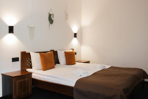 a bedroom with a bed with white sheets and orange pillows at ZimaSnow Ski & Spa Club in Bukovel