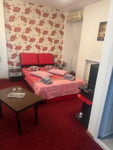 a bedroom with a red bed and a table at Casa Alex in Piteşti