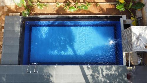 a swimming pool with blue water in at Sigiriya Dream Inn in Sigiriya