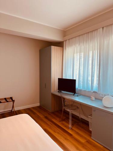 a bedroom with a desk with a computer on it at Il Giardinetto - Guest Room Policlinico in Messina