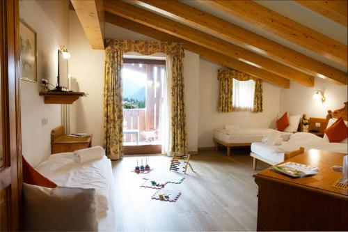 a living room with a bed and a window at Hotel Bonapace ***S in Madonna di Campiglio