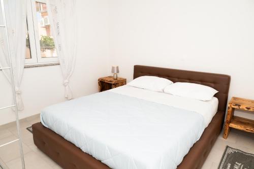 a bedroom with a bed with white sheets and a window at Four Points in Vir