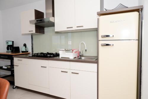 a white kitchen with a sink and a refrigerator at Four Points in Vir