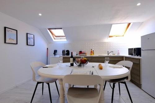 a kitchen and dining room with a white table and chairs at Verneuil - Ciné Room in Verneuil d’Avre et d’Iton