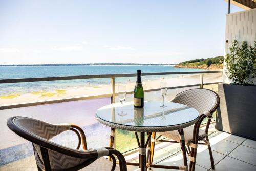 a table with a wine bottle and two chairs on a balcony at Valinor - Charming studio - Concarneau beach in Concarneau