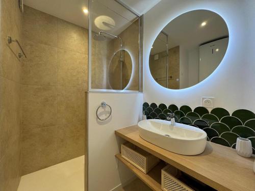 a bathroom with a sink and a mirror at Valinor - Charming studio - Concarneau beach in Concarneau