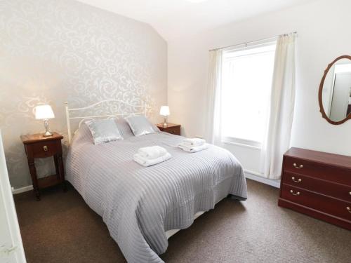 a bedroom with a bed with two towels on it at Twrog, 3 bedroom house in Blaenau-Ffestiniog