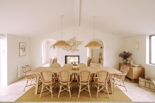 een eetkamer met een tafel en stoelen bij Villa Rhétaise - Loix in Loix