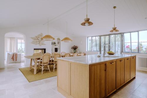 een keuken en eetkamer met een tafel en stoelen bij Villa Rhétaise - Loix in Loix
