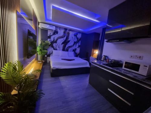 una camera con letto e una cucina con luci blu di REOApartment a Wuse