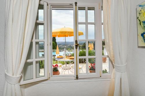 an open door to a patio with an umbrella at Le Hameau in Saint-Paul-de-Vence