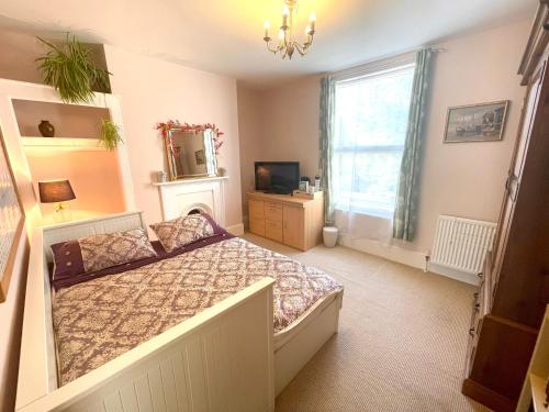 a bedroom with a bed and a mirror and a window at Victorian Rooms by Beach in Ramsgate