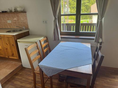 a kitchen with a table with a blue table cloth on it at Penzion Pláně in Nové Hutě