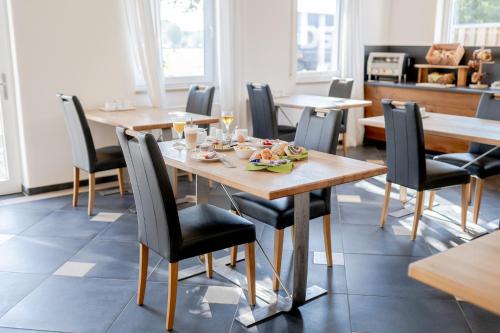 a dining room with wooden tables and chairs at Hotel Donau-Ries in Mertingen