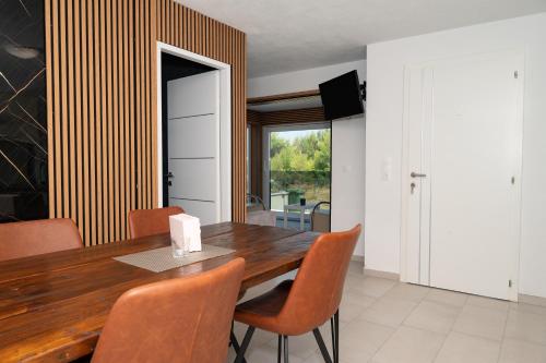 a dining room with a wooden table and chairs at Four Points in Vir