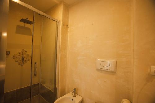 a bathroom with a toilet and a glass shower at 4 Balconi rooms-Boutique B&B in Lecce