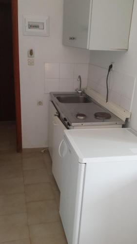 a small kitchen with a stove and a refrigerator at Rooms Leonidas in Kissamos