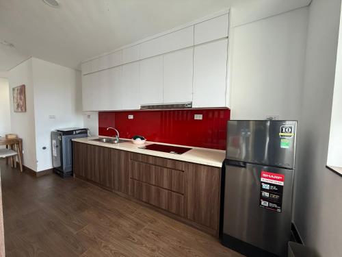a kitchen with a stainless steel refrigerator and wooden cabinets at Sun View Homestay in Ha Long