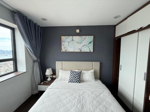 a bedroom with a bed with a blue wall at Sun View Homestay in Ha Long