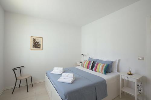 une chambre blanche avec un lit et une chaise dans l'établissement Stay Smart Pisa - parcheggio privato, à Pise