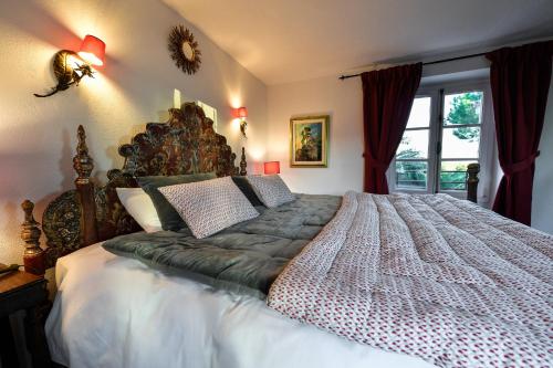 a large bed in a bedroom with a window at Le Hameau in Saint-Paul-de-Vence