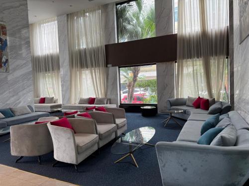 a living room with couches and tables and windows at Sun View Homestay in Ha Long