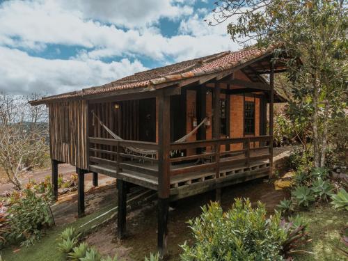a small wooden house on a stand in a garden at Pousada Pedra Azul in Pedra Azul