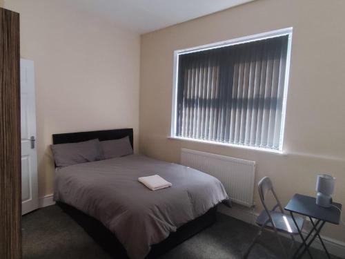 a bedroom with a bed and a window and a chair at En-Suite Double-Bedroom in the Heart of Salford Manchester CR1 Perfect for Short Stays in Manchester