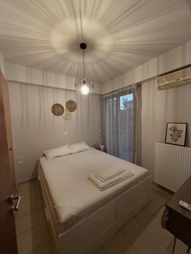 a bedroom with a white bed with towels on it at VillaGer in Kalamata
