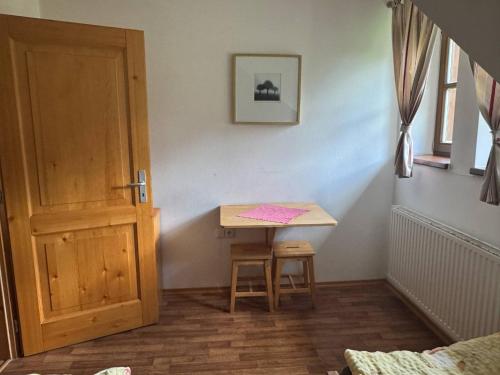 a room with a small table and a door at Penzion Pláně in Nové Hutě