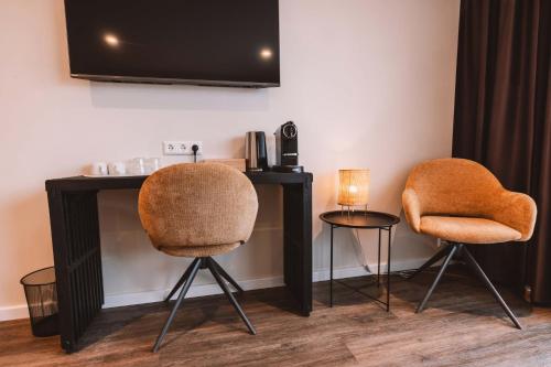 a room with two chairs and a desk and a television at Farmhotel Efstidalur in Laugarvatn