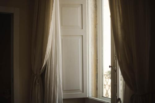 an open door with a curtain and a window at 4 Balconi rooms-Boutique B&B in Lecce