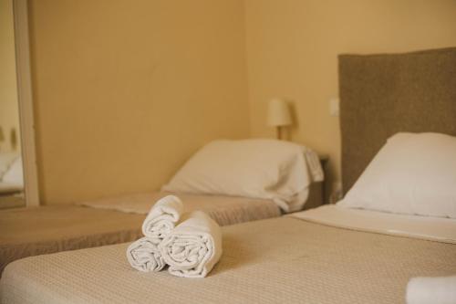 two beds with towels on them in a hotel room at 4 Balconi rooms-Boutique B&B in Lecce