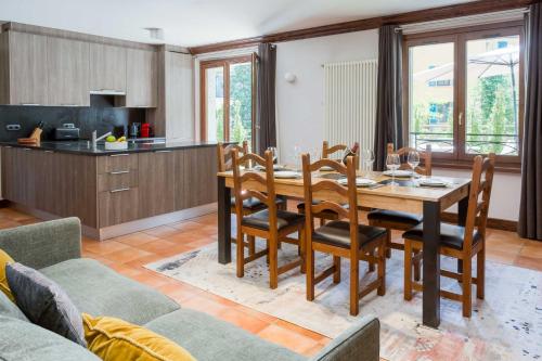 une cuisine et une salle à manger avec une table et des chaises en bois dans l'établissement Pothecary apartment -Chamonix All Year, à Chamonix-Mont-Blanc