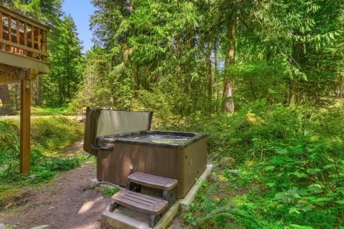 an outdoor grill with a chair in the woods at The Burrow at Zig Zag in Rhododendron