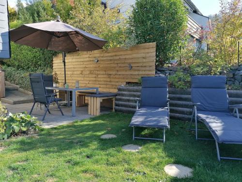 a patio with a table and chairs and an umbrella at Auszeit Sauerland in Olsberg