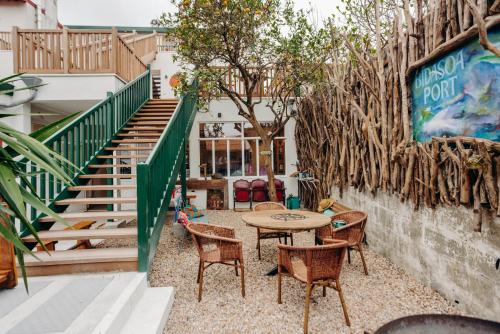 a patio with a table and chairs and stairs at Hostel Demain c'est loin in Hendaye