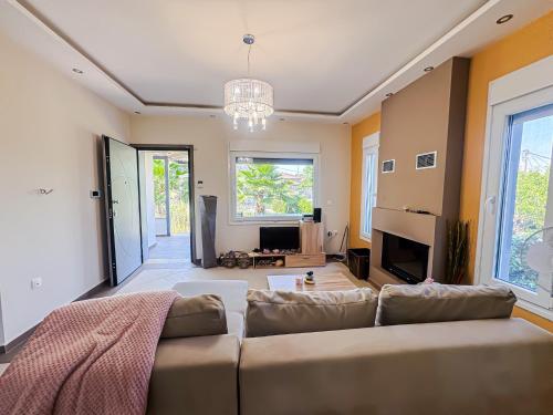 a living room with a couch and a tv at Tereza's Sea Haus in Nea Kalikratia