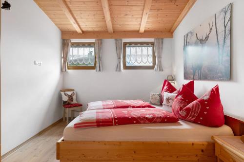 a bedroom with a bed with red pillows at Untertalhof in Castelrotto
