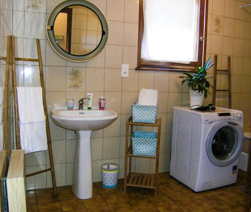 une salle de bain avec un lavabo et une machine à laver dans l'établissement Mélodie lumineuse et spacieuse à 6km du Pal, à Dompierre-sur-Besbre