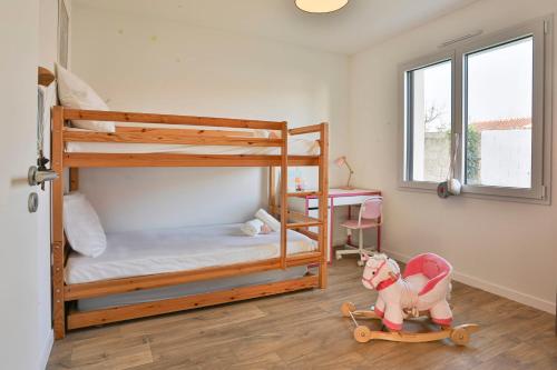 a bedroom with two bunk beds and a toy dog on a skateboard at Brem sur mer - Maison familiale in Brem-Sur-Mer
