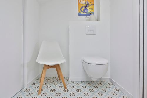 a white room with a chair and a floor at Brem sur mer - Maison familiale in Brem-Sur-Mer