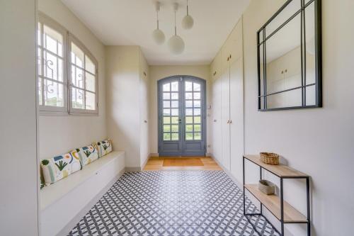 a hallway with a blue door and a tile floor at Magnifique Cottage viticole, portes de St Emilion in Saint-Hippolyte