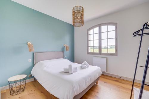 a bedroom with a large white bed and a window at Magnifique Cottage viticole, portes de St Emilion in Saint-Hippolyte