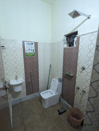 a bathroom with a toilet and a sink at San Unik Homestay in Nilambūr